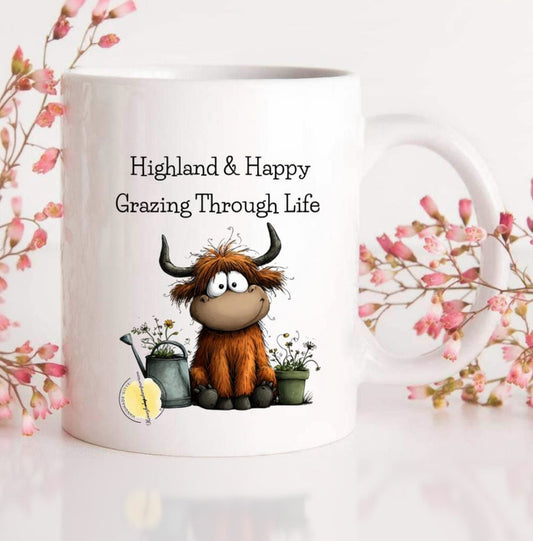 White mug with cartoon Highland cow and floral design on a white background