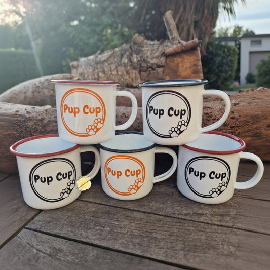 Set of 'Pup Cup' mugs on a wooden surface with a natural background